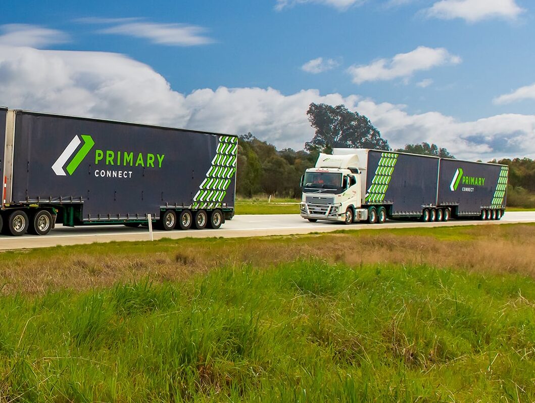 Primary Connect truck with green branding driving on a rural road.