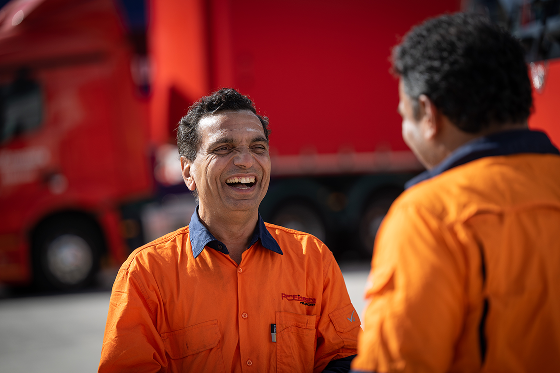 Ron Finemore team member smiling and talking to a colleague at the depot.